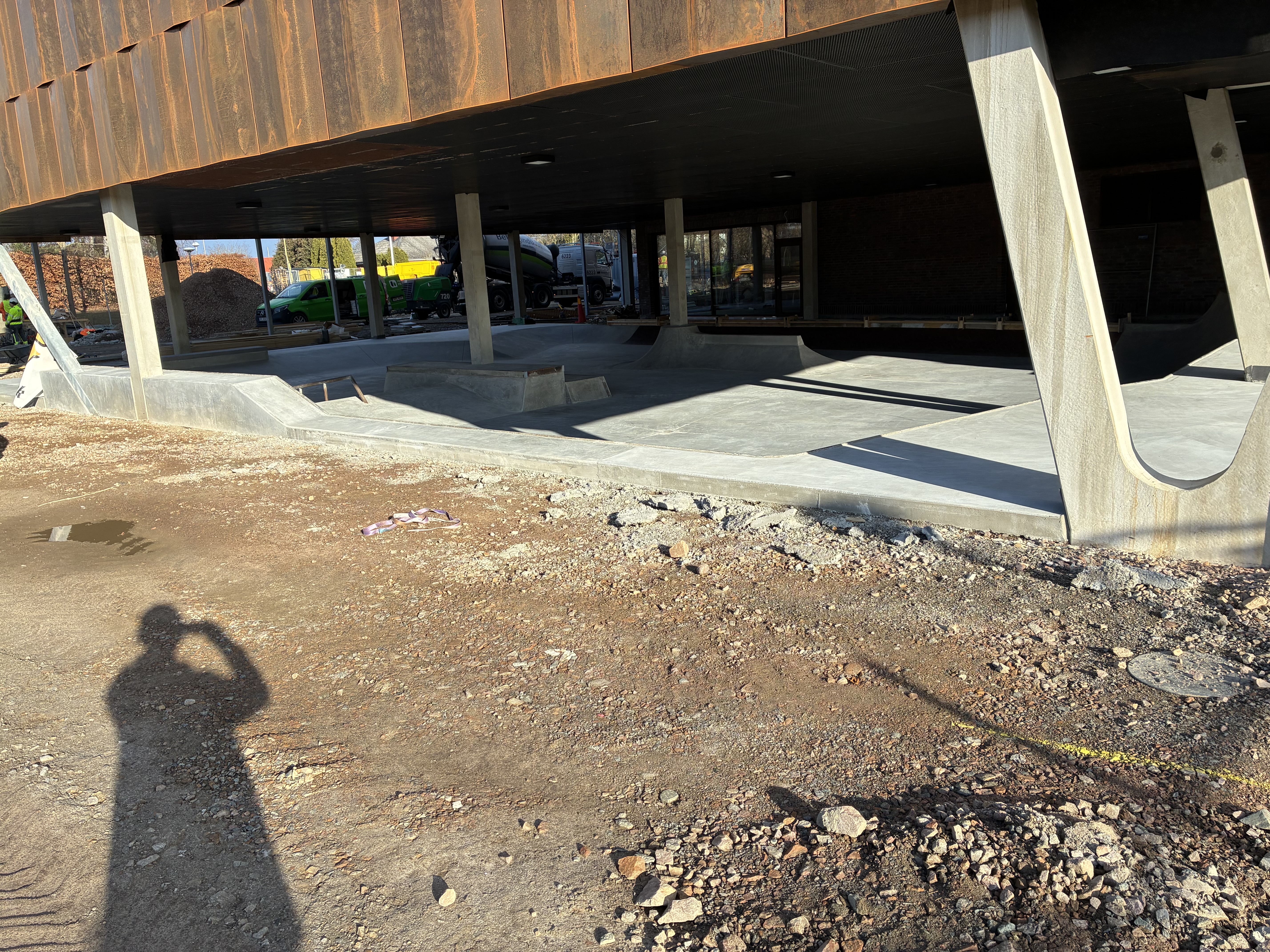 Byggarbetsplats med ett modernt stålkonstruktionstak och betongstöd.