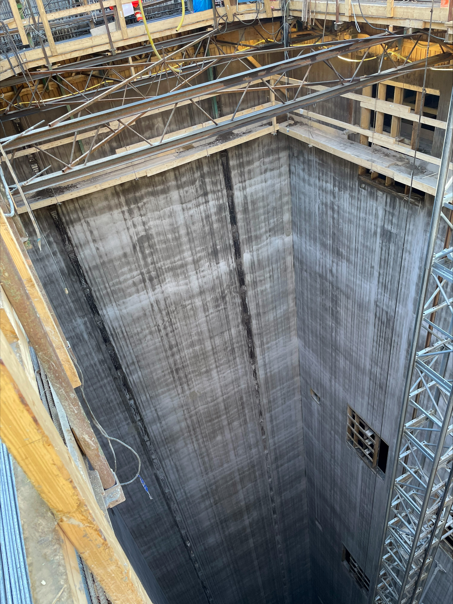 Djup hissschakt med omgivande byggnadsställningar.
