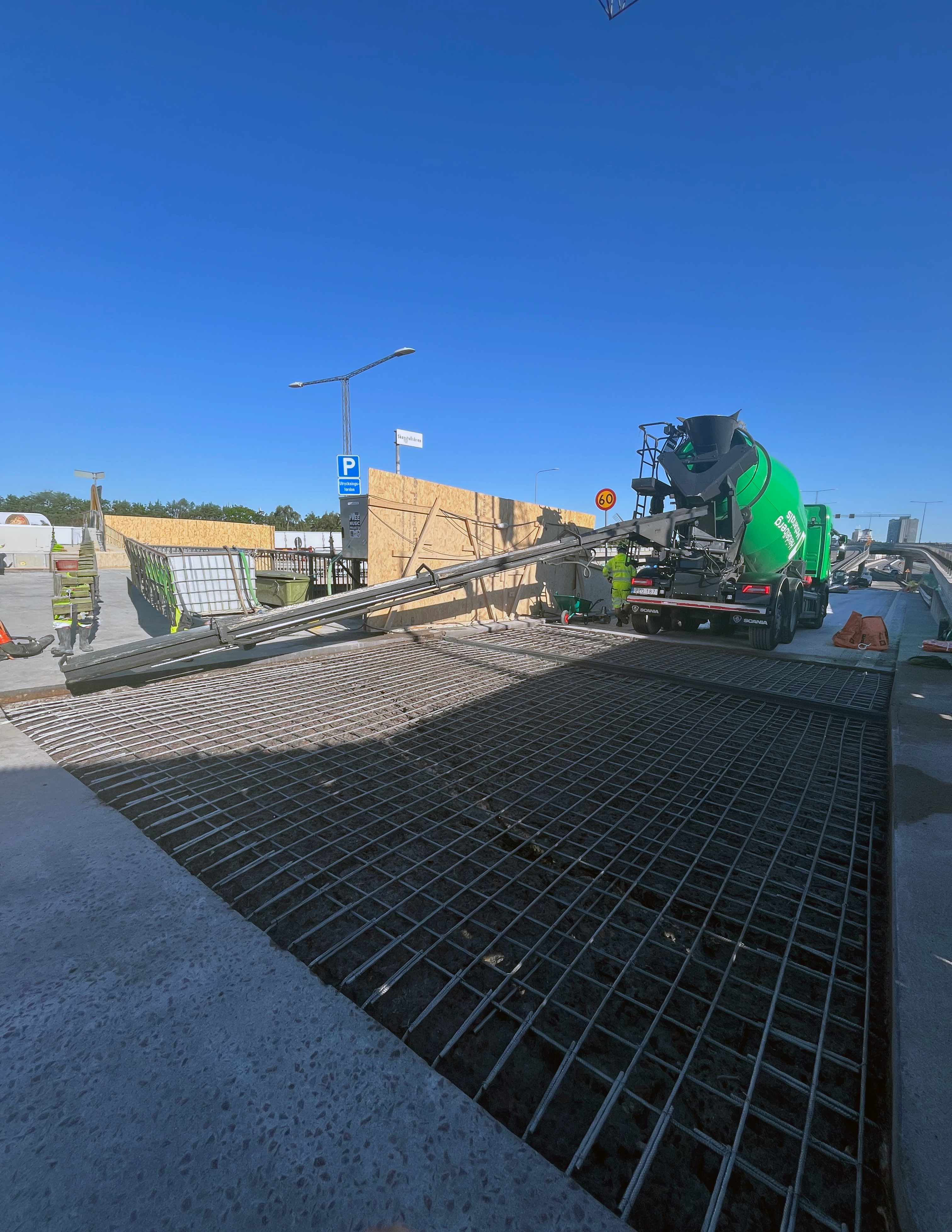 Betong levereras från en betonglastbil till en byggarbetsplats med armeringsjärn i fokus.